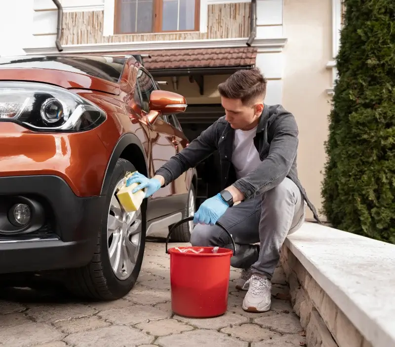 Lavage auto à domicile Saint-Nom-la-Bretèche : professionnel intervenant sur un véhicule